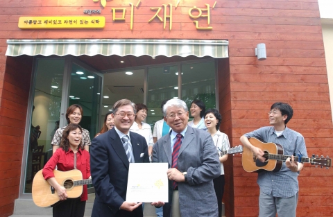 아모레퍼시픽 서경배 대표와 아름다운재단 박상증 이사장이 2004년 7월에 개점한 희망가게 1호점 앞에서 기념촬영을 하고 있다.