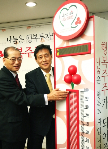 7일 사회복지공동모금회에서 열린 하나은행 공익신탁 성금 전달식에서 (좌로부터) 사회복지공동모금회 윤병철회장과 하나은행 김정태은행장이 행복온도탑의 온도를 올리는 모습임