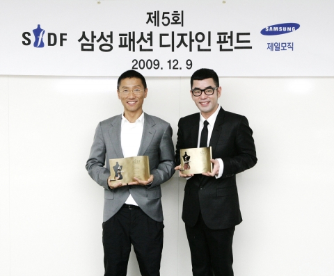 제일모직 제 5회 삼성패션디자인펀드(SFDF)의 수상자인 클루(clu)의 이진과 정욱준이 수상 트로피를 들고 환하게 웃고 있다.