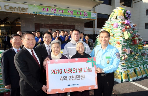 현대차 신영동 국내영업본부장(앞줄 좌측)이 서울모범운전자연합회 최영식 회장(앞줄 우측)에게 쌀 나눔 사업 기금을 전달하는 모습.