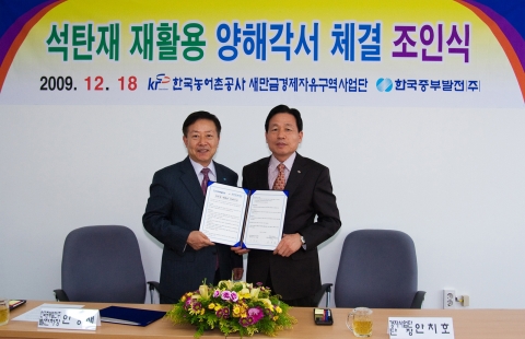 한국중부발전 안경재 발전처장(왼쪽)과 새만금경제자유구역사업단 안치호 단장이 양해각서에 서명한 뒤 기념촬영을 하는 장면