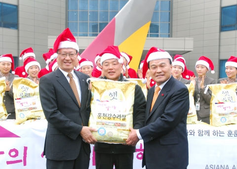 아시아나항공 윤영두 사장(맨 앞열 왼쪽)이 23일 강서구 오쇠동 아시아나타운에서 김재현 강서구청장(맨 앞열 오른쪽) 및 아시아나 승무원들과 함께 산타복장을 하고『사랑의 쌀 나눔』 