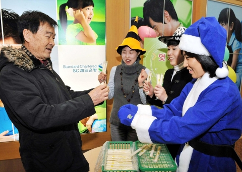 SC제일은행 ‘행복드림 축제 한마당’ 행사에서 공평동 지점을 방문한 고객이 직원들과 엿치기를 하고 있는 모습