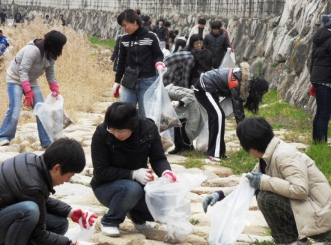 제3회 클린월드운동에 참여한 부산지역 위러브유운동본부 회원들이 쓰레기를 줍고 있다.