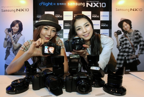 삼성디지털이미징 홍보도우미들이 新개념 렌즈 교환식 전략 카메라 'NX10'을 소개하고 있다.