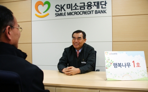 SK미소금융재단 이사장인 신헌철 SK에너지 부회장이 20일 서울 영등포구 대림동 재단 사무실에서 1호 대출 대상자인 최모씨(57.포장마차 운영)씨를 상대로 대출 상담을 하고 있다.