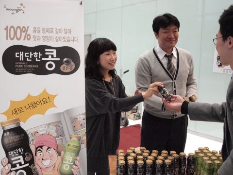25일 오전 서울 충무로 극동빌딩에서 웅진식품 직원들이 신제품 ‘대단한 콩 검은콩’을 직장인들에게 나눠주고 있다.
