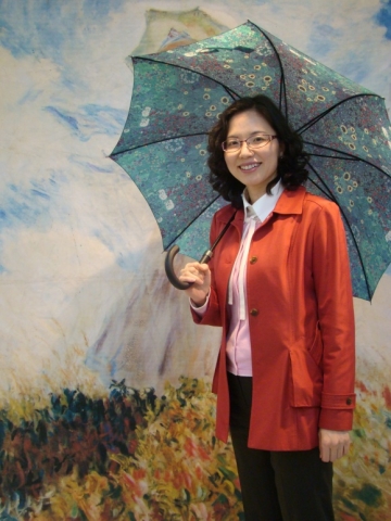 모네의 양산을 쓴 부인 작품 앞에서 한 학부모가 명화따라 사진을 찍고있다