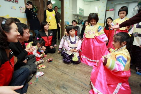 남양주시 외국인근로자복지센터의 보육시설을 찾은 KT 사랑의 봉사단과 IT서포터즈 봉사자들이 아이들에게 세배하는 방법을 알려주고 있다.