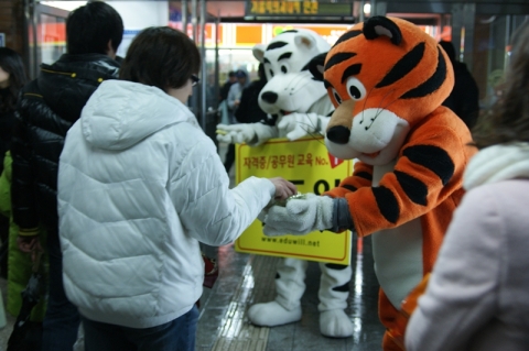 지난 9일 자격증/공무원 전문 교육기업 에듀윌의 직원들이 백호와 호랑이 인형 탈을 직접 쓰고 ‘2010 설 맞이 떡’을 시민들에게 나누어주고 있다.