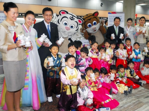 11일 김포공항 국내선 아시아나카운터 앞에서 아시아나항공 김재일 서비스본부장(맨 뒷열 왼쪽 세번째)과 아시아나 공항직원들이 한복을 입은 어린이들에게 『경인년 백호 저금통』을 전달 후 기념촬영을 하고 있다.