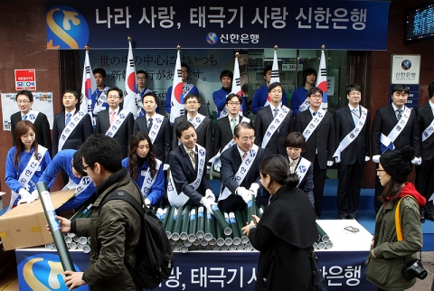 신한은행 이백순 은행장이 명동에서 시민들에게 태극기를 나눠주고 있는 모습