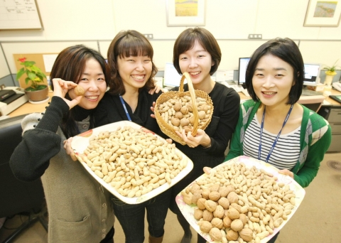 서울체신청 금융검사팀 여직원들이 부럼으로 받은 잣과 호두를 들고 포즈를 취하고 있다.