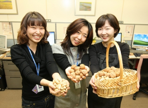 서울체신청 금융검사팀 여직원들이 부럼으로 받은 잣과 호두를 들고 포즈를 취하고 있다.