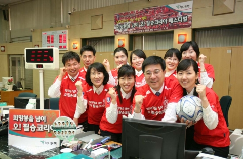 3일 을지로 하나은행 본점 영업부 직원들이 한국축구대표팀의 승리를 기원하며 D-100일 행사로 붉은색 축구대표팀 응원복을 입고 근무하고 있다.