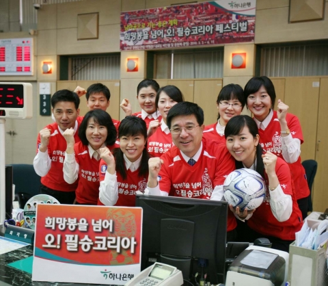 3일 을지로 하나은행 본점 영업부 직원들이 한국축구대표팀의 승리를 기원하며 D-100일 행사로 붉은색 축구대표팀 응원복을 입고 근무하고 있다.