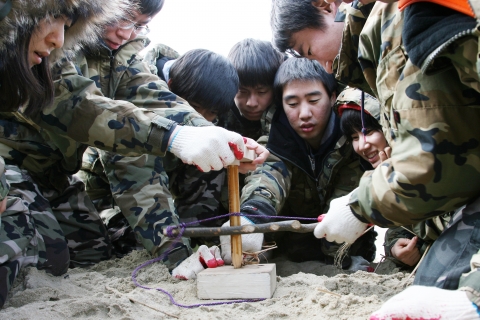 행사에 참여한 신입사원들이 전통적인 방법으로 불을 직접 피우고 있다.