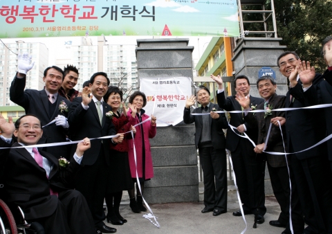 행복한학교 제1호 염리초등학교 현판식 -현판 중심 우측: 김영숙 행복한학교재단 이사장, 라진구 서울시 행정1부시장, (모르는사람), 신헌철 SK부회장 -현판중심 왼측: 신성숙 삼전초등학교장, 이희장 염리초등학교장, 강승규 마포구 국회의원, 이은결 마술사 휠체어 타신분(고정욱 작가)