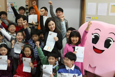 16일, 굿네이버스 세계시민교육 일일 강사로 나선 배우 김현주와 서울 운현초등학교 학생들이 제3세계 아이들에게 직접 쓴 편지를 들고 환하게 웃고 있다.