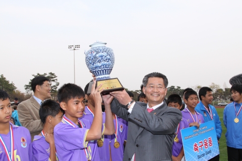 25일 열린 경기도 수원컵 국제유소년 축구대회 시상식에서 우승한 태국대표팀과 경기도수원월드컵경기장관리재단 송기출 사무총장과 트로피를 들어 올리고 있다.