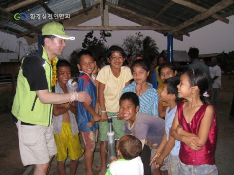 ▲쌍퉁 허이난스마을에 시공된 우물앞에서 환실련 관계자와 어린아이들이 모여 장난을 하고 있다.