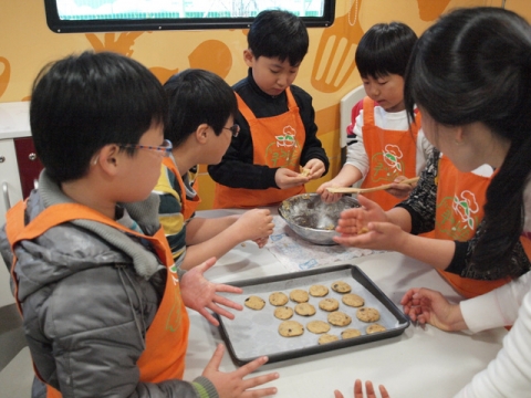 한국청소년단체협의회가 운영중인 쿠킹버스에서 서울 광희초등학교 학생들이 직접 쿠키를 굽고 있다.