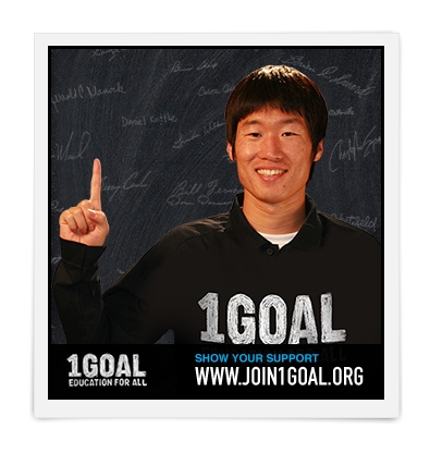 축구선수 박지성이 세계 초등교육 확산 지지를 위한 모바일 서명운동 1골 캠페인에의 참여를 격려하며 손가락으로 숫자 1을 만들어 내밀고 있다.