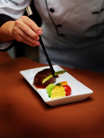 출장연회 행사를 준비하고 있는 호텔 주방장이 정성스럽게 음식을 장만하고 있다.