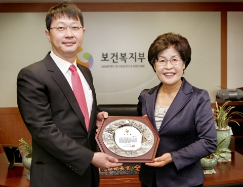 최재원 SK㈜ 부회장(왼쪽)이 25일 서울 종로구 계동 보건복지가족부 장관실에서 SK그룹을 대표해 전재희 보건복지가족부 장관(오른쪽)으로부터 장례문화 발전에 기여한 공로로 감사패를