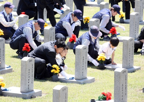 남궁민 우정사업본부 본부장을 비롯한 우체국 집배원들과 어린이들이 26일 오전 서울 동작구 국립현충원에서 현충일을 앞두고 호국영령의 정신을 기리기 위해 돌볼 사람이 없는 묘역을 찾아