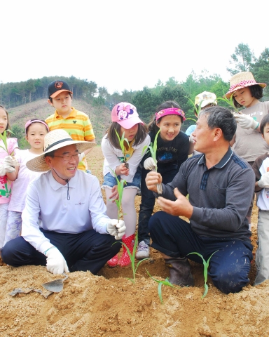 5월 29일(토) 류광희 아시아나항공 여객본부장(앞줄 좌측)과 아시아나 임직원 자녀들이 자매결연을 맺은 강원도 홍천군 외삼포 2리에서 옥수수 심기 봉사활동에 대한 사전설명을 듣고