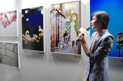 삼성전자 카메라 모델 한효주가 '삼성 NX10 Creative Photo Gallery' 행사에 참가하여 전시된 사진들에 대해 소개하고 있다.