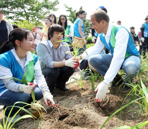 3일 오후 서울시 강서 습지생태공원에서 열린 &#039; 세계 환경의 날 맞아 식목행사’에서 리차드 힐 한국스탠다드차타드금융지주 대표이사 겸 SC제일은행장이 파트너십을 맺고 있는 복지기관 장애우와 대학생 홍보대사 ‘영스탠다드차타드’ 2기 학생과 함께 한 조를 이루어 나무를 심고 있다.