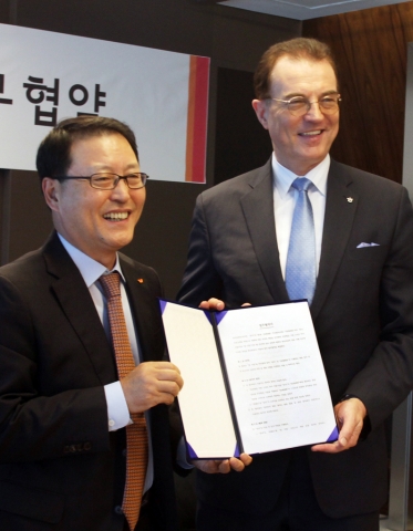 SK텔레콤 정만원 CEO(좌측)와 한국관광공사 이참 사장이 조인식에서 업무 협약서에 서명 한 후 포즈를 취하고 있다.