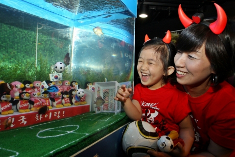 10일 부산아쿠아리움에서 진행된 ‘물고기 월드컵경기’에서 붉은 악마들이 대한민국을 대표하는 붉은 물고기를 응원하고 있다.