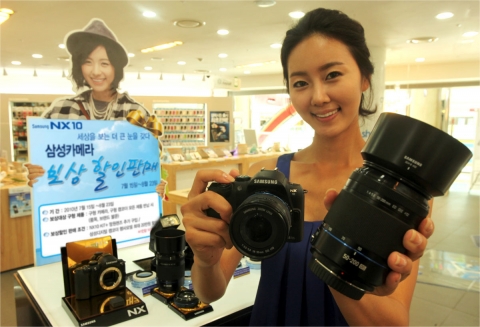 삼성 모바일샵 롯데월드점에서 삼성전자 모델이 NX 망원렌즈 보상 할인 판매 행사를 소개하고 있다.