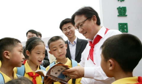 중국삼성 박근희사장이 린쟝소학교 학생들과 함께 책을 읽고 있다.