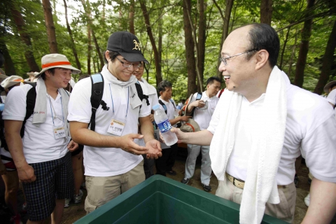한화그룹 김승연 회장이 오늘 오후 문경새재에서 그룹행사 <사랑의 행진> 중 그룹 임직원 및 인턴사원들과 휴식을 취하며 음료수를 나눠주고 있다.