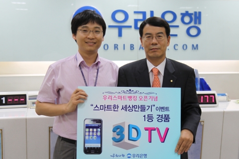 우리은행은 16일 ‘우리스마트뱅킹 이용고객 경품대잔치’ 당첨자를 발표하고, U뱅킹사업단 서만호 단장과 1등 당첨고객이 경기도 의왕지점에서 기념촬영을 하고 있다.