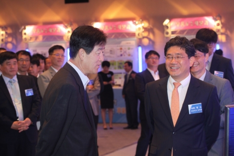 삼성전자 최지성 대표이사와 루멘스 유태경 대표이사가 전시회를 둘러보며 담소를 나누고 있다.