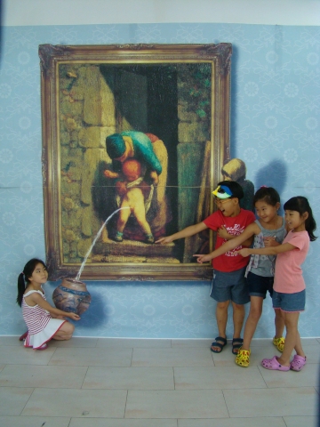 밀레작 &#039;어머니와 아들&#039;패러지 작품에서 요강을 들고있는 어린이를 같이온 아이들이 손으로 가리키며 즐거워하고 있다