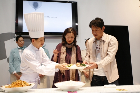 행사에 참석한 일본인 커플이 무대 위에서 비빔밥을 직접 비벼볼 수 있는 행사에 참여하고 있다.