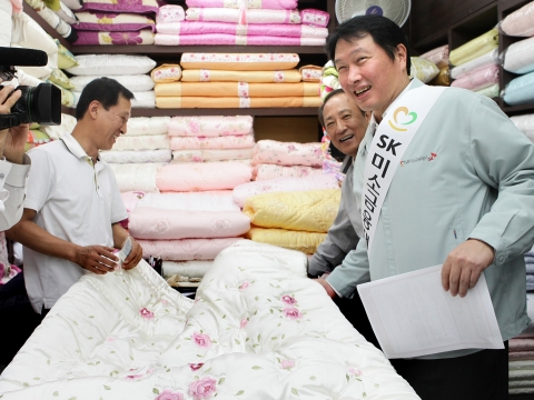 최태원 SK그룹 회장(오른쪽)과 김승유 미소금융중앙재단 이사장(오른쪽 두번째)이 7일 서울 종로구 광장시장의 한 이불가게에 들러 상인에게 미소금융 상품을 소개하고 있다.