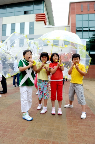 투명우산을 받은 어린이들이 우산을 써 보는 모습.