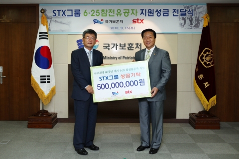 이종철 STX그룹 부회장이 김양 국가보훈처장에게 6.25 참전유공자 지원 성금을 전달하고 있다