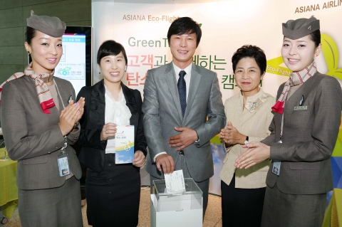 29일 인천국제공항 아시아나항공 카운터 앞에서 열린 &lt;아시아나 탄소상쇄 참여 캠페인&gt;행사에서 아시아나항공 환경•고객담당 한현미 상무와 승무원들이 참여고객들과 함께 기념촬영을 하고 있다.