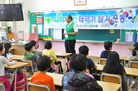 새마을지도자고양시협의회 유금석 회장이 초등학생을 대상으로 태극기에 대하여 설명하고 있다.