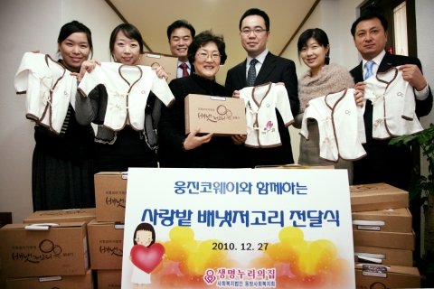 웅진코웨이 김상준 전략기획본부장(오른쪽 세번째)과 동방사회복지회 강영숙 원장(오른쪽 네번째)을 비롯한 임직원들이 동교동에 위치한 동방사회복지회에서 손수 만든 배냇저고리와 지원금 전