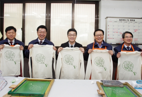 SK텔레콤과 오르그닷 대표들이‘CEO 사회적기업 릴레이 자원봉사'의 일환으로 직접 만든 친환경 티셔츠를 들고 기념 촬영을 하고 있다. (사진 왼쪽부터) 박용주 SK텔레콤