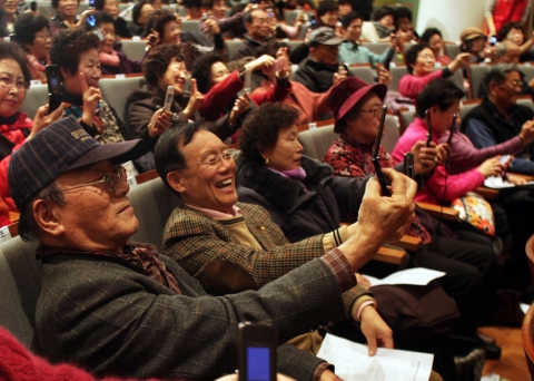 3일 SK텔레콤이 개최한 제 1회 이음페스티벌에 참가한 160여명의 어르신들이 포토메일을 보내기 위해 자신의 얼굴을 휴대폰 카메라로 촬영하고 있다.